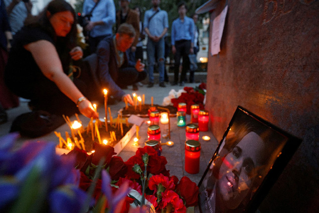 Russians lay flowers and light candles at a makeshift memorial in Darya Dugina's honour in a Moscow street