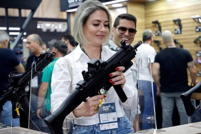 A visitor holds a weapon during the Shot Fair Brasil, an arms exhibition in Joinville, Santa Catarina state. August 5, 2022.